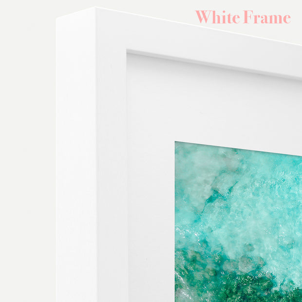 a white frame with a picture of a green ocean